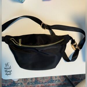 black fanny pack with adjustable strap and gold zipper